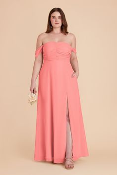 a woman in an off the shoulder coral colored dress, with her legs slited