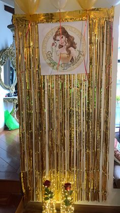 a table topped with lots of gold decorations and lights next to a poster on the wall