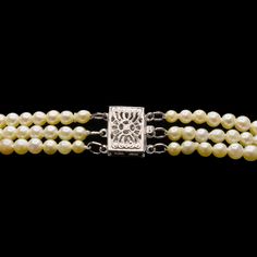 This stunning necklace contains three strands of graduated, cream colored vintage Akoya pearls strung on silk with knots between each pearl. The strands are linked by an antique style filigree box clasp made of 14 karat white gold. The outer strand measures 26", the middle strand measures 24", and the inner strand measures 22". Metal: 14K White Gold (the clasp) Main Stones: Round Cream Colored Akoya Pearls (graduated from 2.65 mm to 8.05 mm) Length: 26" Vintage Akoya Pearl Necklace For Formal Occasions, Antique Pearl Necklace For Formal Occasions, Vintage Single Strand Akoya Pearl Jewelry, Vintage Akoya Pearl Necklace, Formal Antique Pearl Drop Necklace, Classic Multi-strand Jewelry For Formal Occasions, Classic Formal Necklace With Box Clasp, Vintage Akoya Pearl Jewelry With Round Beads, Elegant Multi-strand Jewelry With Sterling Silver Clasp