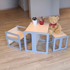 a teddy bear sitting at a small wooden table with two cubbys on it