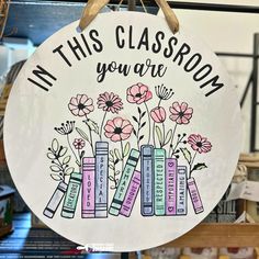 a sign that says in this classroom you are surrounded by books with flowers on them