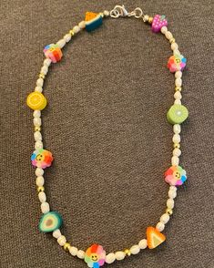 a multicolored beaded necklace with charms on it's sides and an initial