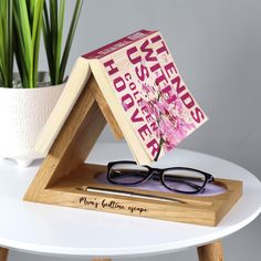 a pair of glasses sitting on top of a wooden stand next to a potted plant