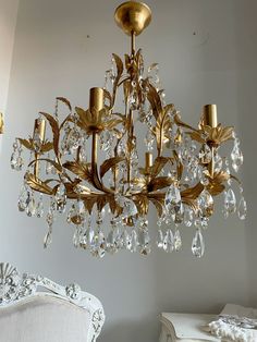 a chandelier hanging from the ceiling in a room with white walls and furniture