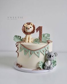 there is a cake decorated with animals on the top and one has a letter in the middle