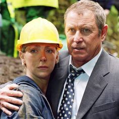 a man and woman wearing hard hats pose for the camera