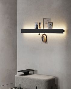 a wall mounted shelf with two lights on it next to a couch and coffee table