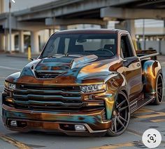 a truck that is painted in metallic and has flames on the hood, front end