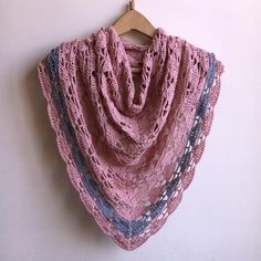 a crocheted shawl hanging on a wall