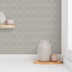 two white vases sitting on top of a counter next to a mirror and shelf