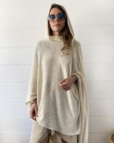 "Off White Knit Cotton Hooded Cape. Cowl Neck Hoodie. Poncho Style. This gorgeous soft tunic is lovingly handmade from an up-cycled cotton blend. It is a part of the collection \"Ceremony White\" - a collection of dresses and pants created specifically for your ceremony journeys, kundalini yoga, sound baths and mediation. Inspired by silent mediation and love for comfortable wear. Material: Up-cycled knit cotton. Very soft, light weight and flowing. Size: One size Overall Length: about 42 in. Ov Oversized Knitted Hoodie Sweater, White Knitted Hooded Sweater, White Hooded Knitted Sweater, Oversized Hooded Knit Top, One Size Cream Long Sleeve Sweater, Beige Long Sleeve Hooded Sweater, Beige Long Sleeve Sweater With Drawstring Hood, Cozy Knitted Hooded Tops, Casual White Hooded Poncho