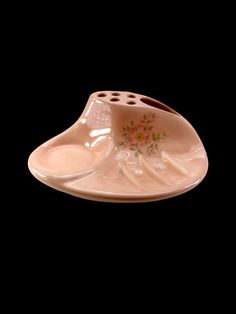 a pink ceramic dish with flowers on it