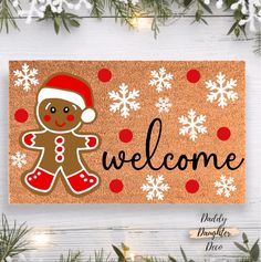 a welcome mat with a gingerbread man on it and snowflakes in the background