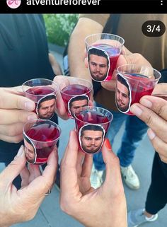 several people holding up cups with pictures on them