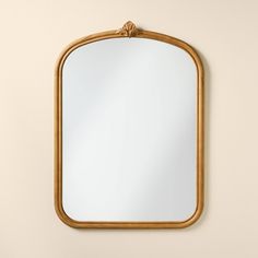 a mirror hanging on the wall next to a shelf