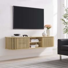 a living room with a black chair and a flat screen tv mounted on the wall