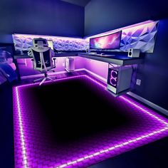 a computer desk with two monitors on top of it in a room filled with purple lighting