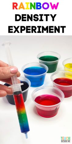 someone is holding a test tube in their hand and there are four different colored liquids