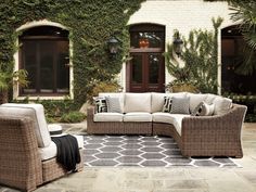 an outdoor living room with wicker furniture