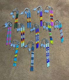 several pairs of beaded earrings are laid out on the floor with hooks and clips