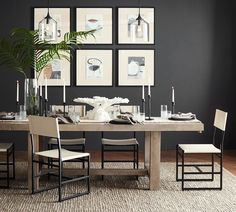 a dining room table with chairs and pictures on the wall