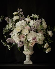 a vase filled with lots of white flowers on top of a black background, says happy birthday to you