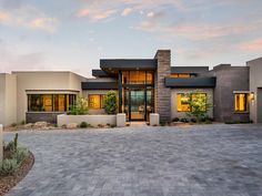 a modern home with large driveway in front of it