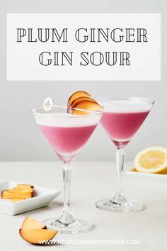 two glasses filled with pink gin sour on top of a white table next to slices of lemon