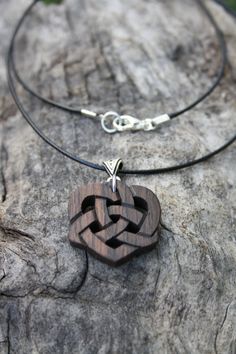 "Adorned with a lovely Trinity Celtic bail, this unique and intricate hand-carved Irish Bog Oak Celtic heart pendant will be made for you, or a loved one, in my studio on the West of Ireland. Bog Oak comes from ancient forests that once covered Ireland. Huge oaks have been buried in peat bogs and preserved from decay by the acidic and anaerobic bog conditions, sometimes for hundreds or even thousands of years. The wood is usually stained black by tannin dissolved in the acidic water. Bog-wood re Symbolic Carved Brown Jewelry, Carved Heart Shaped Jewelry Gift, Carved Heart-shaped Jewelry For Gift, Carved Heart Jewelry Gift, Artisan Engraved Heart-shaped Jewelry, Artisan Engraved Heart Jewelry, Heart-shaped Carved Jewelry Gift, Heart Shaped Carved Jewelry Gift, Celtic Heart