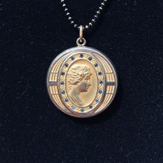 "This elegant Art Deco gold filled locket features a finely sculpted profile of a lovely lady surrounded by an oval ring of dark glittering paste stones and another ring of interesting engravings. The back of the locket has the initials \"RB\" engraved in Edwardian-style lettering. Inside, you can see the letters \"C, Q, and R\" in a small triangle which indicates the jewelry company who crafted this locket was the esteemed Carter, Qvarnstrom, & Remington of Attleboro, MA (they produced lock Antique Oval Pendant Jewelry With 17 Jewels, Art Deco Hallmarked Oval Jewelry, Hallmarked Oval Art Deco Jewelry, Victorian Engraved Oval Cabochon Jewelry, Elegant Bronze Cameo Jewelry, Art Deco Oval Jewelry With Polished Finish, Antique Commemorative Round Jewelry, Antique Round Jewelry For Commemoration, Gold Oval Pendant With Cameo Detail