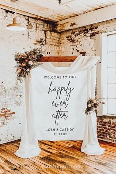 the welcome sign is hanging on the wall in front of an open doorway with flowers and greenery