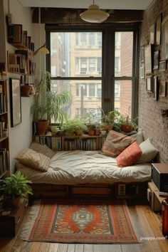 a room with a couch, bookshelf and plants in the window sill