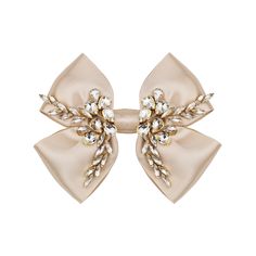 a pair of hair clips with bows and crystals on top of each one in beige