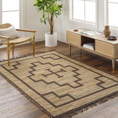 a living room with a rug, chair and potted plant