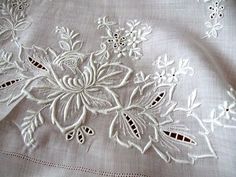 an embroidered white cloth with flowers on it