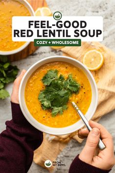 a person holding a bowl of red lentil soup