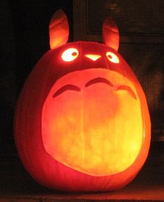 a pumpkin shaped like a totoro with glowing eyes