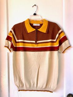 Brand new!! Never tried on!! Ordered wrong size by mistake. This is a wonderful sweater top for your vintage man!! Retro ribbed polo top in beige, brown, gold, and maroon. Vintage 70s style stripe panel detailing. Zip neck. Fabric: Cotton, Lycra, Polyester. Care: Machine wash, dry flat. Men's Size Small. Brown Collared Polo Sweater, Casual Brown Collared Sweater, Casual Brown Collared Polo Sweater, Brown Short Sleeve Tops With Ribbed Collar, Casual Brown Cotton Polo Sweater, Brown Collared Polo Sweater For Fall, Fall Cotton Crew Neck Polo Shirt, Vintage Brown Top For Winter, Vintage Brown Tops For Winter