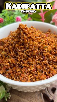 kadi pata chutney in a white bowl on a table with flowers