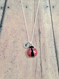 "This listing is for a hand-stamped initial necklace featuring a 7/10\" x 1/2\" silver plated and red enamel ladybug charm & 3/10\" stainless steel initial pendant. The silver plated chain is 18\" long, but can be made to your desired length- see last photo in listing for length guide. Please indicate the chain length you would like in the 'notes to seller' section at checkout. All items are lead & nickel free. Message me with any questions, thank you! Add an initial to any necklace http Cute Round Red Jewelry, Cute Red Round Jewelry, Red Charms Jewelry For Birthday, Dainty Red Personalized Charm Necklaces, Dainty Personalized Red Charm Necklaces, Red Personalized Jewelry For Mother's Day, Adjustable Red Necklace For Birthday, Adjustable Red Personalized Necklace, Personalized Red Jewelry For Mother's Day