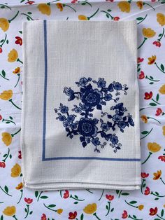 a blue and white flowered napkin on top of a bed