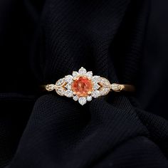 Product Details Make a timeless statement with this classic floral ring, featuring a round-cut orange sapphire and Diamond halo. This orange sapphire engagement ring is the perfect piece for a woman. Product Information SKU SHP-RINGS0821219756 Width 4 mm Height 7.8 mm Weight 1.92 gm (Approximate) ORANGE SAPPHIRE INFORMATION No.of Stones 1 Pieces Total Weight 0.34 Carat (Approximate) Dimension(approx) Round-4X4 mm-1 Pcs Color Orange Cut Brilliant Shape Round Setting Type Claw-Set Quality Grade AAA DIAMOND INFORMATION No.of Stones 24 Pieces Total Weight 0.31 Carat (Approximate) Dimension(approx) Round-0.80X0.80 mm-12 PcsRound-1.20X1.20 mm-6 PcsRound-1.60X1.60 mm-6 Pcs Color HI Cut Brilliant Shape Round Setting Type Claw-Set Quality Grade SI View More Product Parent Collection Handle orange-s Orange Engagement Ring, Yellow Gold Anniversary Rings, Blue Sapphire Diamond Ring, Orange Cut, Gold Anniversary Rings, Green Emerald Ring, Flower Engagement Ring, Gold Anniversary, Floral Ring