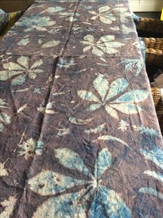 a bed with a blue and white flowered bedspread on top of it