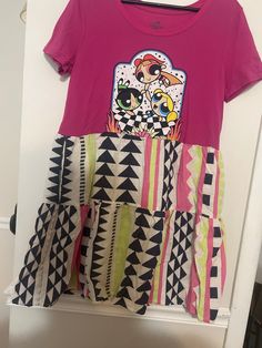 This is a Flowy upcycled t shirt dress, handmade by me. The t shirt is sized large but I'd say it would fit a L/Xl, just depending on how you like it to fit, and is roughly 20in at the waist when dress is laid flat and 34in in length. this dress also has pockets! Pink Patchwork T-shirt For Summer, Cotton Graphic Print T-shirt Dress With Short Sleeves, Pink Patchwork Short Sleeve T-shirt, Pink Cotton Patchwork T-shirt, Pink Patchwork Cotton T-shirt, Cotton Dresses With Graphic Print In Cute Style, Casual Patchwork Dress With Crew Neck, Casual Patchwork Crew Neck Dress, Casual Crew Neck Patchwork Dress