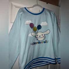 a blue shirt with an image of a sheep holding balloons on it's chest