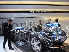 a man standing next to a car on display