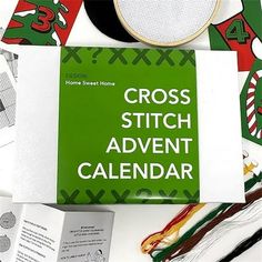 the cross stitch calendar is laying on top of other items