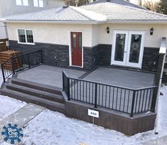 a house with snow on the ground and steps leading up to the front door,