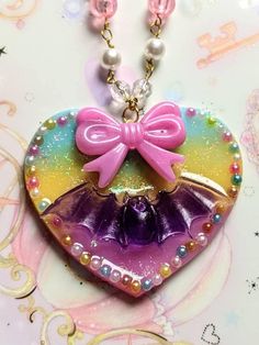 For all pastelgoth lovers. Cute large heart and bat necklace adorned with ribbon and iridescent elements. Hanging from a beaded chain. Magical perfection! The heart is 6/6 cm. Glittery Jewelry, Pink Goth, Bat Necklace, Kawaii Goth, Ribbon Necklace, Epoxy Resin Crafts, Kinds Of Clothes, Choker Necklaces, Pastel Goth