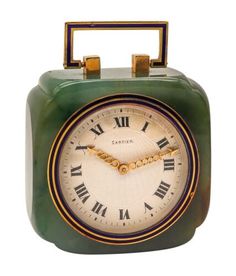 an old fashioned clock with roman numerals on the face and green plastic case